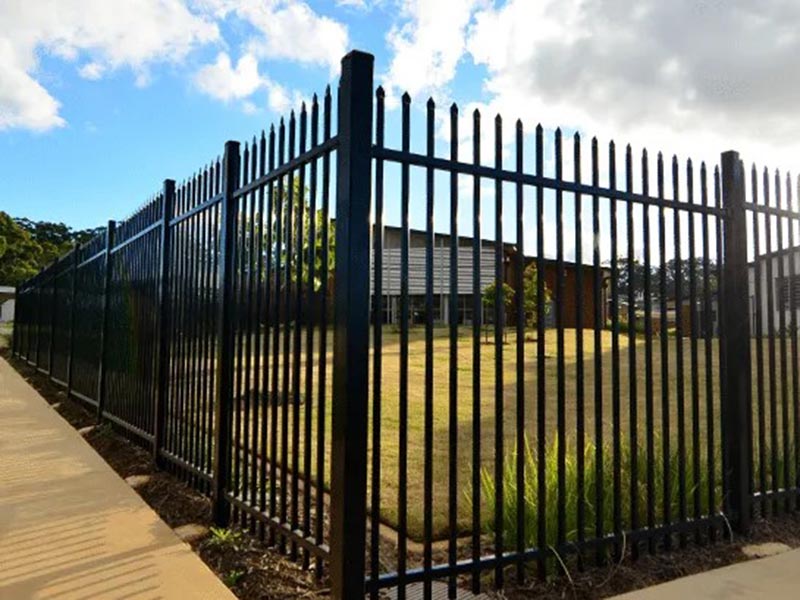 Black metal picket security fencing surrounding a residential back yard